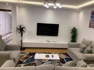 a living room with a flat screen tv on a white wall at شارع لبنان - المهندسين - القاهرة مصر in Cairo