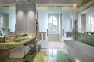 a bathroom with a tub and a toilet and a sink at Vista Palazzo - Small Luxury Hotels of the World in Como