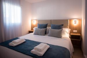 een slaapkamer met een groot bed en 2 handdoeken bij MAR BIANCO - Gay Men Only in Maspalomas