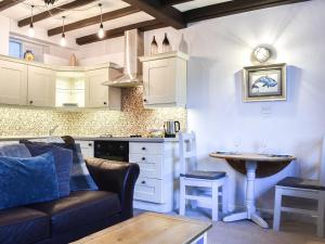 uma cozinha e sala de estar com um sofá e uma mesa em Sea Dog Cottage - Uk42479 em Whitby