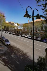 een straatlicht aan de kant van een straat met geparkeerde auto's bij Rosetta Burger Queen in Cagliari