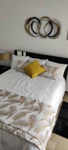 uma cama com lençóis brancos e almofadas em Casa da Avó Biza em São Roque do Pico