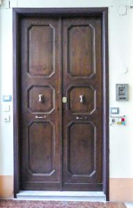 a large wooden door with three panels on it at Rosetta Burger Queen in Cagliari