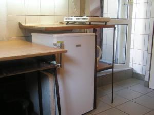 a small white refrigerator in a kitchen with a table at A-Netflix parking kawalerka mała Halczyna 9 doCentrum 6 przystanków in Kraków