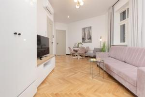 Praga Duplex Apartment Premium Warsaw by Renters في وارسو: غرفة معيشة مع أريكة وطاولة