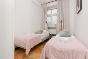 sypialnia z 2 łóżkami i oknem w obiekcie Praga Duplex Apartment Premium Warsaw by Renters w Warszawie