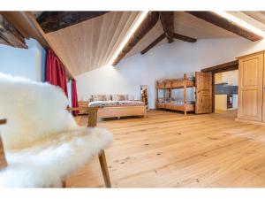 een woonkamer met een bed en een houten vloer bij Wohnung von Schorsch in Splügen