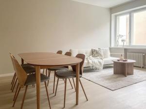 a dining room table and chairs in a living room at Central 1BR next to the park in Helsinki