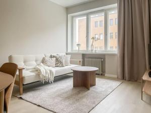 ein Wohnzimmer mit einem weißen Sofa und einem Fenster in der Unterkunft Central 1BR next to the park in Helsinki