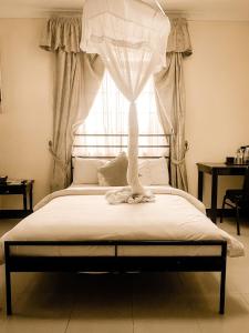 Cama en habitación con ventana en M Hotel, en Dar es Salaam