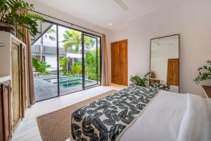 a bedroom with a bed and a large window at Yogi Surf Villas Complex Canggu in Canggu