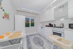 a kitchen with white cabinets and a table and chairs at Villa with Pool and Backyard in Kepez 