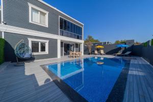 a swimming pool in front of a house at Villa with Pool and Backyard in Kepez 