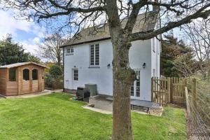 a white house with a bench in a yard at GEORGEHAM WHITEHAVEN 3 Bedrooms in Georgeham