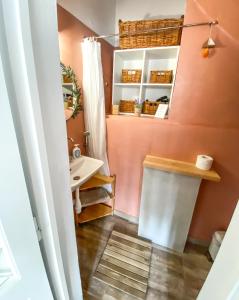 baño con paredes de color rosa y lavabo en La Pausa en Porto Heli
