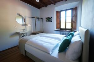 a bedroom with a bed with a mirror and a window at Ar Convént B&B in Bigorio