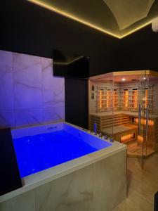 a large blue bath tub in a room with a kitchen at Suite Élite in Catania