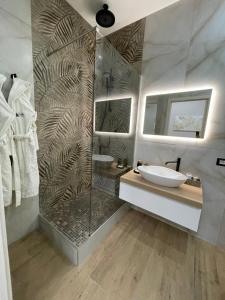 a bathroom with a shower with a sink and a mirror at Suite Élite in Catania
