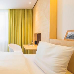 a bedroom with a white bed and a desk at Hotel Luise in Erlangen