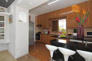 a kitchen with wooden cabinets and white appliances at Villa Polina in Ayia Napa