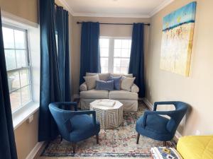 een woonkamer met een bank en 2 stoelen bij Bleu Beach Resort in Indialantic