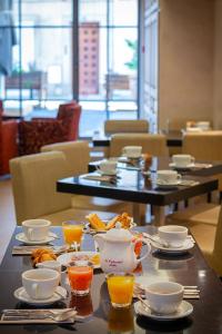 アルルにあるホテル スパ ル カレンダルの食べ物と飲み物の盛り合わせが付いたテーブル