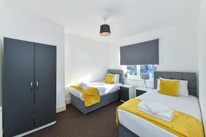 a bedroom with two beds and a tv at Hillside House in Nottingham