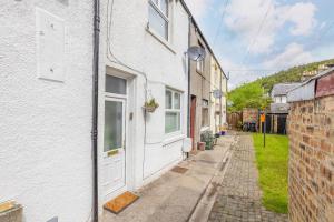 an alley in a white house with a white door at Cosy town centre cottage in Peebles