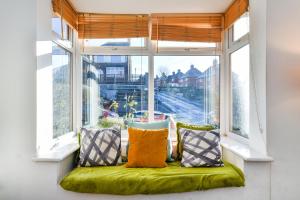 a window seat with a green cushion and pillows at Hillside House in Nottingham