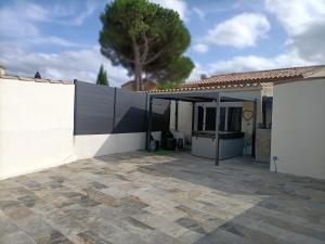 a white house with a fence and a patio at Bulle d'évasion in Trèbes