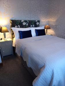 a bedroom with a large white bed with blue pillows at Middlethorpe Apartment in York