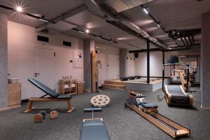 a gym with several exercise equipment in a room at Hotel Pollux in Zermatt