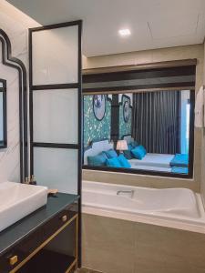 a bathroom with a bath tub and a bedroom at Tony Apartment -FLC Sea Tower Quy Nhon in Quy Nhon