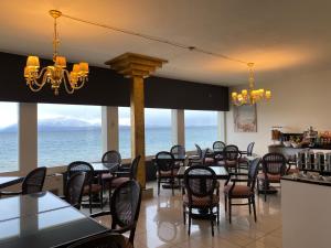 a restaurant with tables and chairs and a view of the ocean at Hotel Estée in Desenzano del Garda