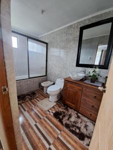 a bathroom with a toilet and a sink and a mirror at Casa de campo Mostazal / Hogar para descansar in El Rincón