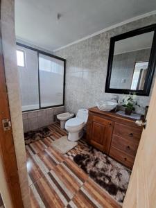 een badkamer met een toilet, een wastafel en een spiegel bij Casa de campo Mostazal / Hogar para descansar in El Rincón