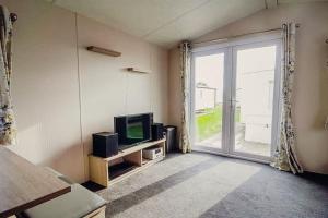 sala de estar con TV y ventana grande en 113 Seawick, 2 Bedrooms Free WiFi, en Jaywick Sands