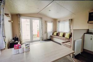 sala de estar con sofá y ventana grande en 113 Seawick, 2 Bedrooms Free WiFi, en Jaywick Sands