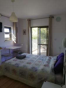 a bedroom with a bed and a table and a window at Desert Sunrise Arad in Arad