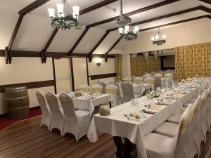 a banquet hall with white tables and white chairs at The Aberdeen Arms Hotel in Tarves