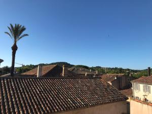 a view of a city with a palm tree and roofs at VILLAGE - DUPLEX lumineux avec vue magnifique sur les toits in Saint-Tropez