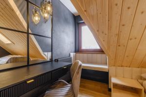 a room with a bed and a chair and a window at Villa 84 & Apartments Jacuzzi & Sauna in Zakopane