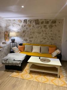 a living room with a yellow couch and a table at Loft en plein cœur du village in Saint-Paul-de-Vence +22 photos