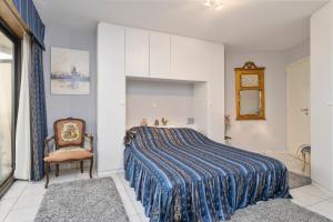a bedroom with a bed and a chair at seaview apartment margo in Blankenberge