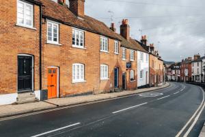 an empty city street with brick buildings and an orange door at Chalk house - Pet friendly in Henley on Thames