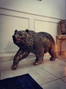 a statue of a brown bear standing on the floor at La Parenthèse Au Bain Nordique in Betton