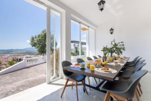 uma sala de jantar com mesa e cadeiras e janelas grandes em Finca Puerto Ermita - Cerca Málaga 20KM - Pizarra em Pizarra
