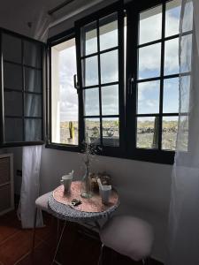 a table in a room with three windows at Habitación Dache Lanzarote in Tías