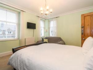 a bedroom with a bed and a couch and a television at Blencathra in Keswick