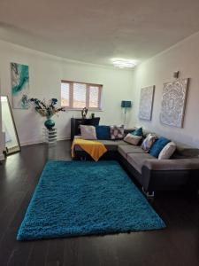 sala de estar con sofá y alfombra azul en Stockton Heights, Warrington, Centrally Located Between Town Centre and Stockton Heath, High Speed Wifi, Cozy Stay, en Warrington